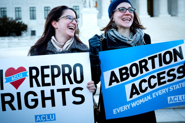 women holding reproductive rights signs outside the Supreme Court