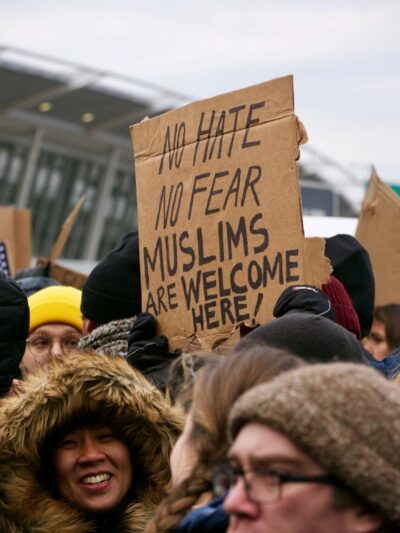 Protesters holding sign that says "No Hate No Fear Muslims Are Welcome Here!"