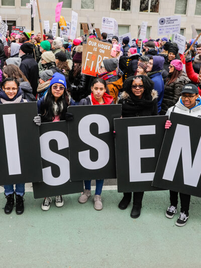 Protesters holding signs that say dissent