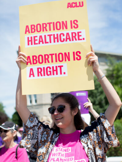 Protester holding sign that reads "Abortion is healthcare. Abortion is a right."