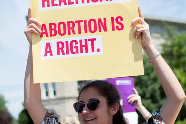 Protester holding sign that reads "Abortion is healthcare. Abortion is a right."