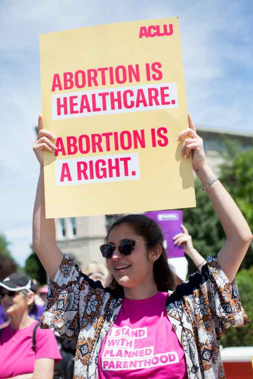 Protester holding sign that reads "Abortion is healthcare. Abortion is a right."