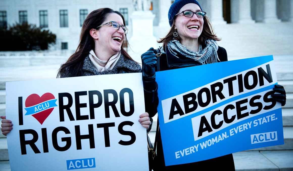 women holding reproductive rights signs outside the Supreme Court