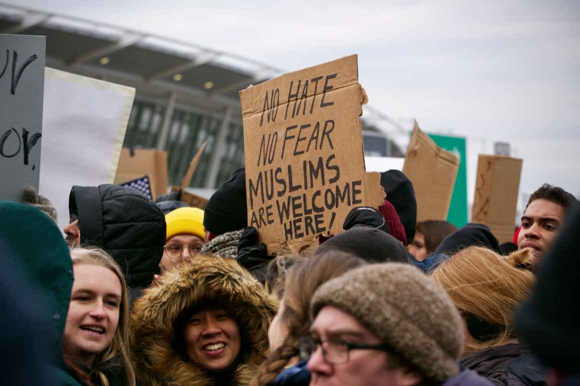 Protesters holding sign that says "No Hate No Fear Muslims Are Welcome Here!"