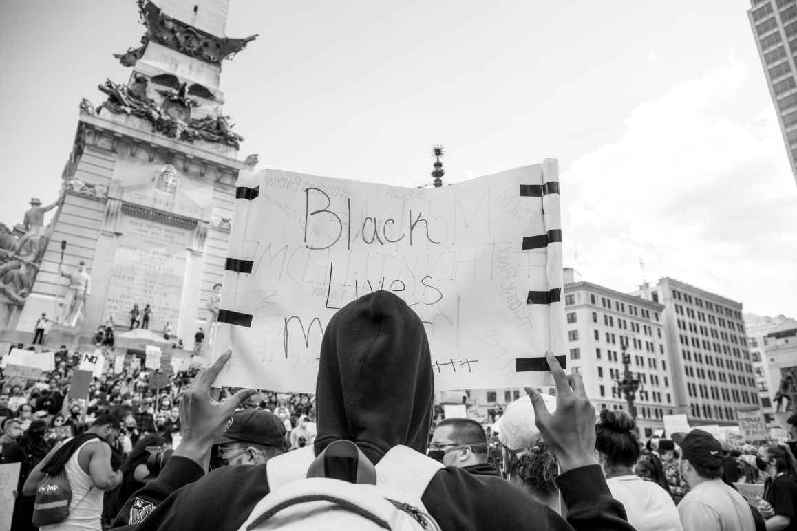 Protester holding black lives matter sign on monument circle