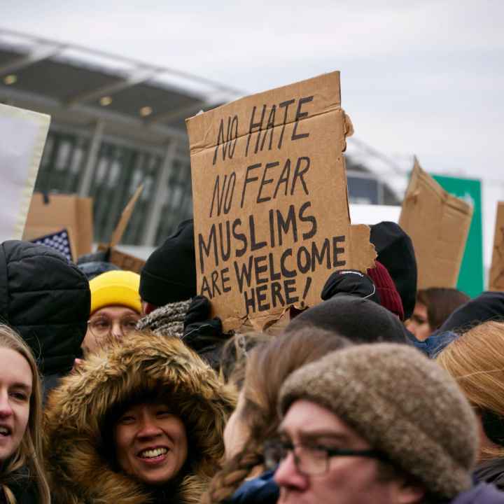 Protesters holding sign that says "No Hate No Fear Muslims Are Welcome Here!"
